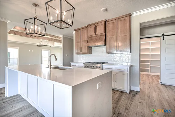 a kitchen with a sink cabinets and wooden floor