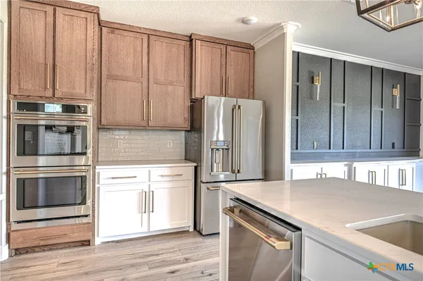 a kitchen with stainless steel appliances granite countertop a refrigerator and a sink