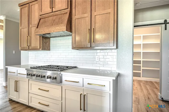a kitchen with white cabinets and a stove top oven