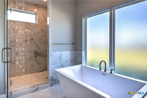 a bathroom with a granite countertop sink a mirror and shower