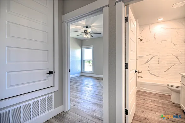 a view of a hallway with wooden floor and staircase