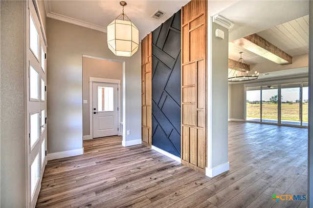 a view of hallway with livingroom and wooden floor