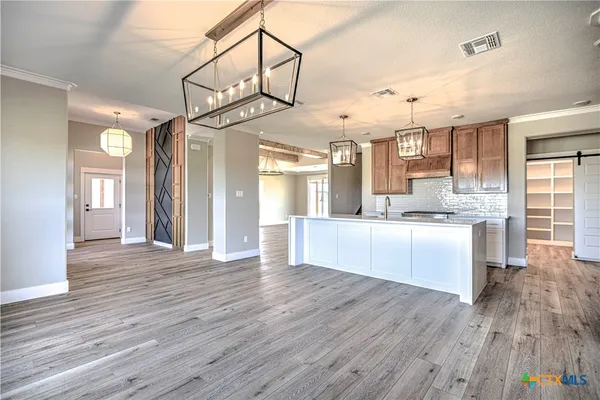 a large kitchen with cabinets and wooden floor