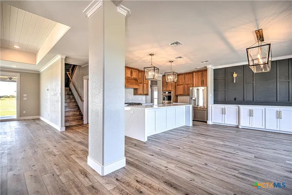 a view of a kitchen with wooden floor and electronic appliances