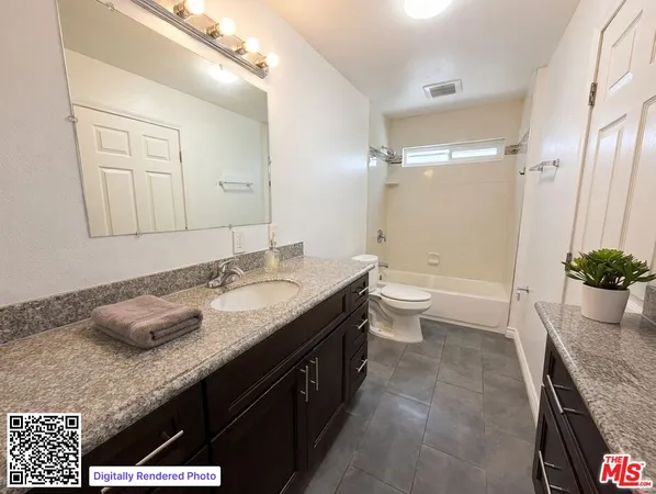 a bathroom with a granite countertop sink a toilet and shower
