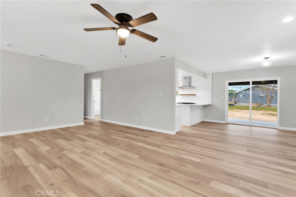 12532 Sholic Road Apple Valley, CA 92308 - Photo 12 of 41 a view of an empty room with a window and wooden floor
