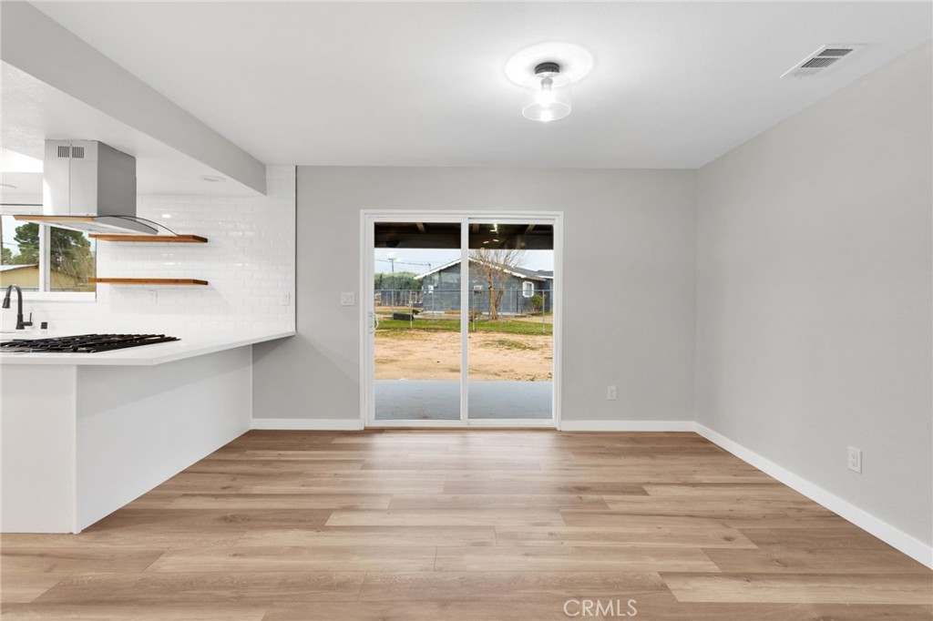 12532 Sholic Road Apple Valley, CA 92308 - Photo 13 of 41 a view of empty room with wooden floor and fan
