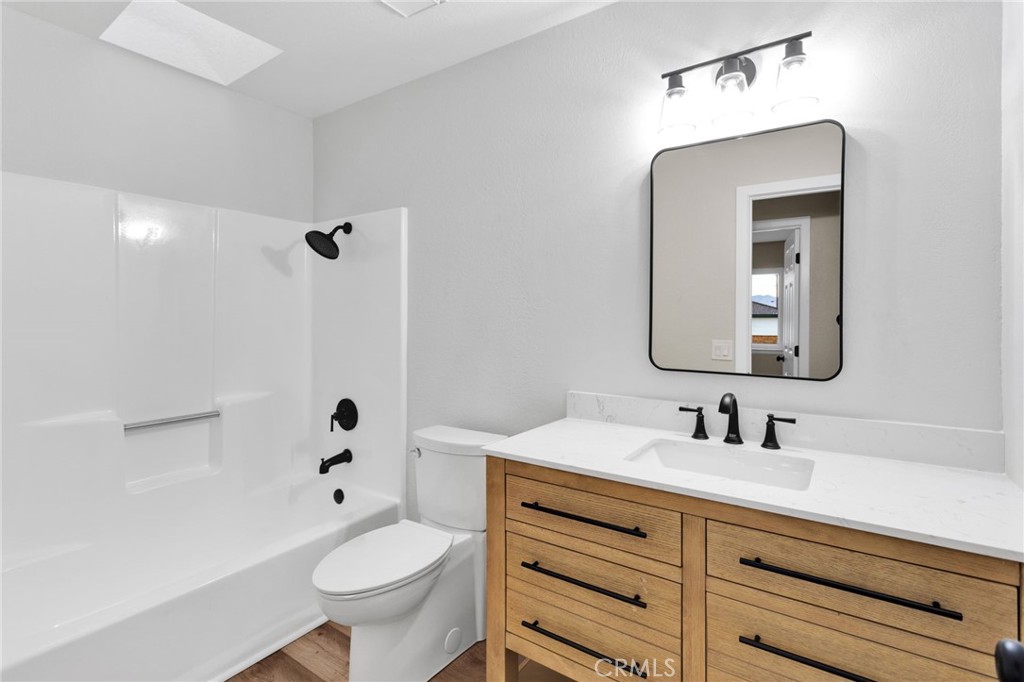 12532 Sholic Road Apple Valley, CA 92308 - Photo 20 of 41 a bathroom with a toilet sink a mirror a shower and vanity