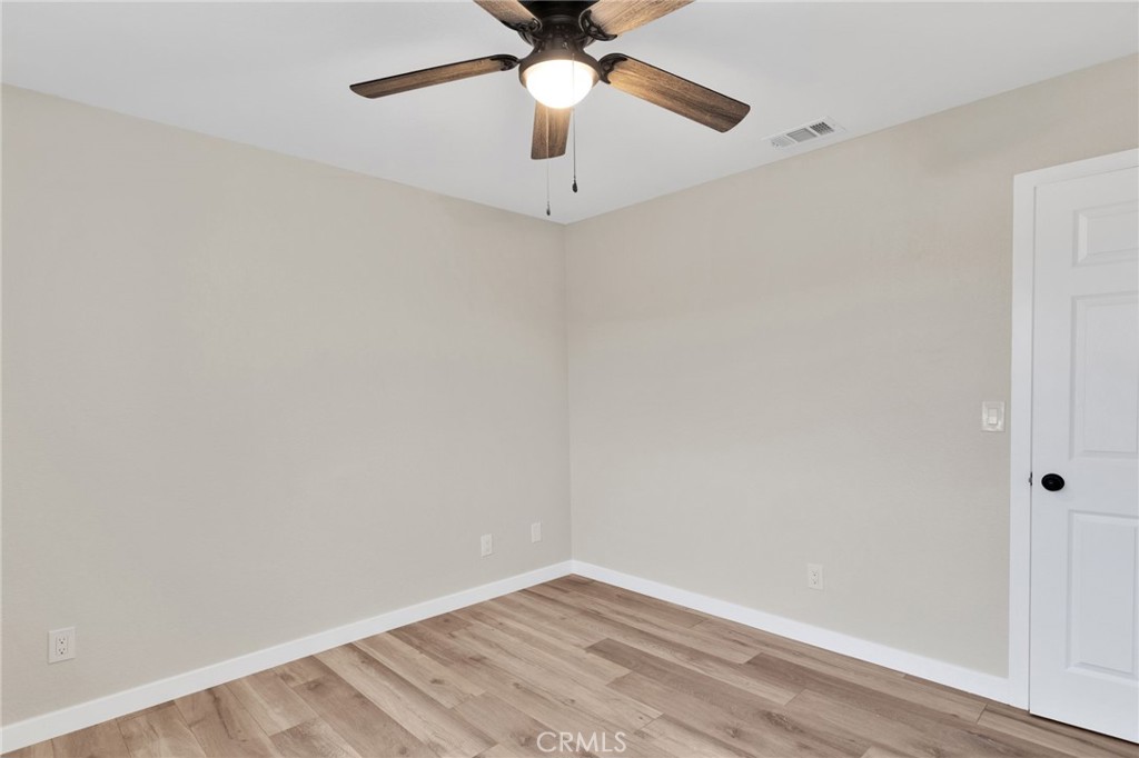 12532 Sholic Road Apple Valley, CA 92308 - Photo 22 of 41 an empty room with a ceiling fan and carpet