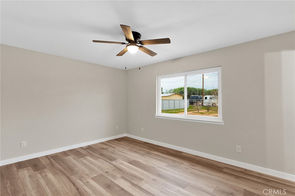 12532 Sholic Road Apple Valley, CA 92308 - Photo 25 of 41 a view of empty room with wooden floor and window