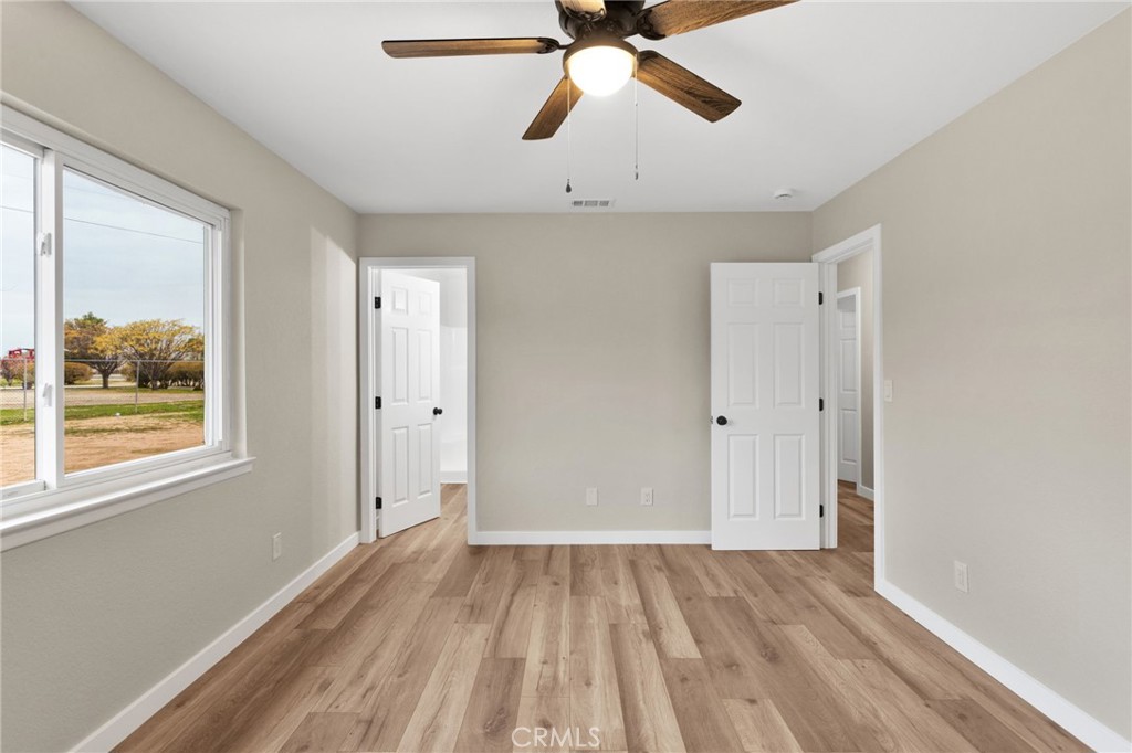12532 Sholic Road Apple Valley, CA 92308 - Photo 27 of 41 a view of empty room with wooden floor and fan