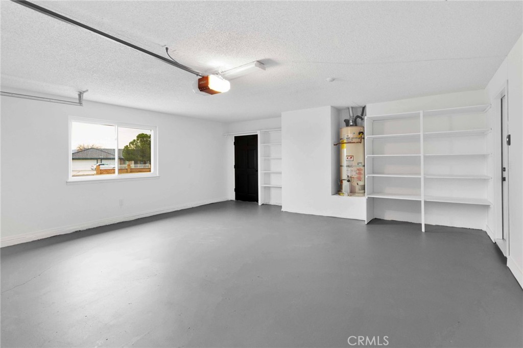 12532 Sholic Road Apple Valley, CA 92308 - Photo 36 of 41 a view of an empty room with a window and a kitchen