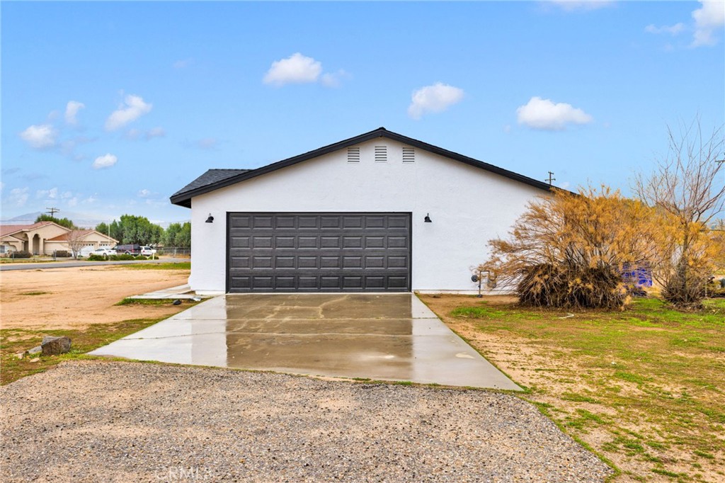 12532 Sholic Road Apple Valley, CA 92308 - Photo 4 of 41 a view of a house with backyard and trees