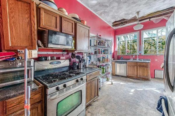 a kitchen with stainless steel appliances a stove and a bookshelf