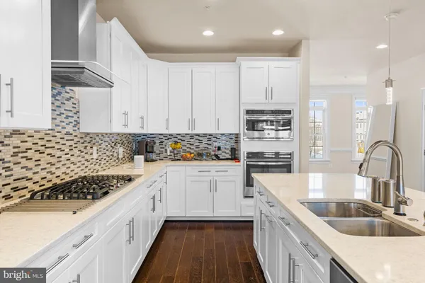 a kitchen with granite countertop a sink and a stove top oven