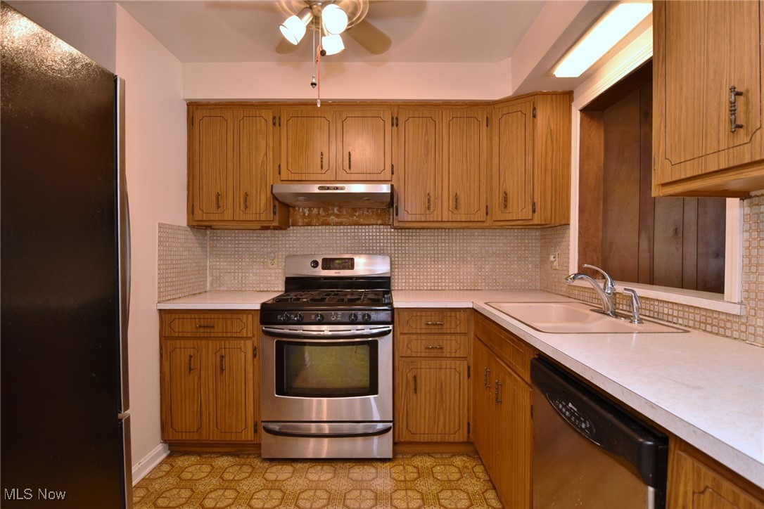 6308 Highland Road Cleveland, OH 44143 - Photo 15 of 40 Kitchen with stainless steel appliances, tasteful backsplash, light countertops, a sink, and under cabinet range hood