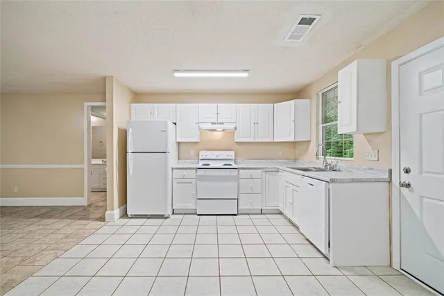 a kitchen with white cabinets and white appliances