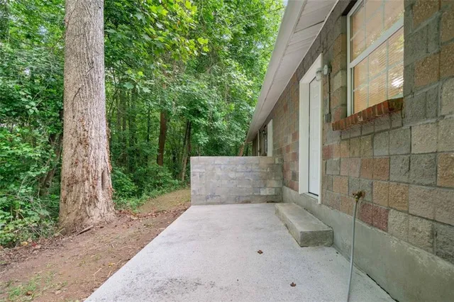a view of a house with backyard and trees