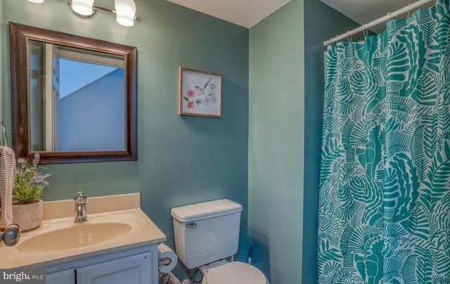a bathroom with a toilet sink and mirror