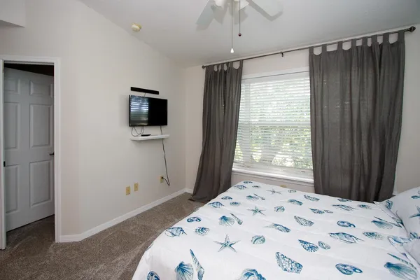 a bedroom with a bed and a flat screen tv