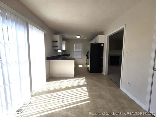 a view of a kitchen with a refrigerator and a window