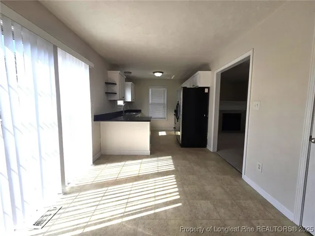 a view of a kitchen with a refrigerator and a window