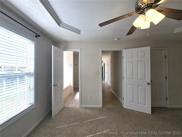 a view of a livingroom with a chandelier fan and windows