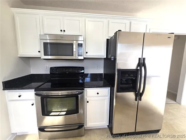 a kitchen with stainless steel appliances granite countertop a refrigerator and a stove