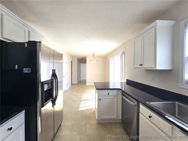 a kitchen with stainless steel appliances granite countertop a refrigerator and a sink