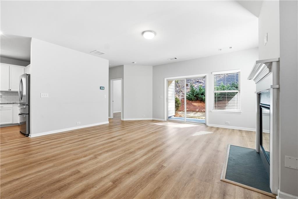 2779 Morgan Spring Trail Buford, GA 30519 - Photo 12 of 64 a view of an empty room with wooden floor and a window