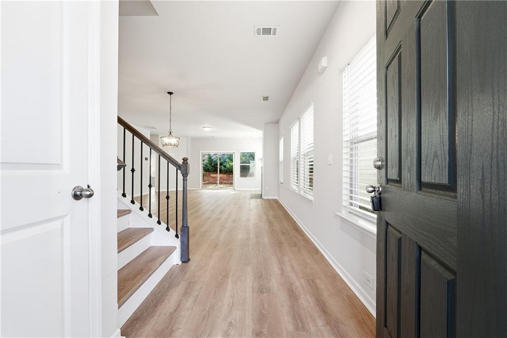 2779 Morgan Spring Trail Buford, GA 30519 - Photo 4 of 64 a view of a hallway with wooden floor and staircase