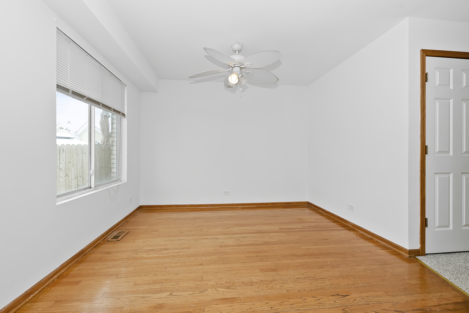 6823 Roberts Road Bridgeview, IL 60455 - Photo 4 of 22 an empty room with windows and ceiling fan