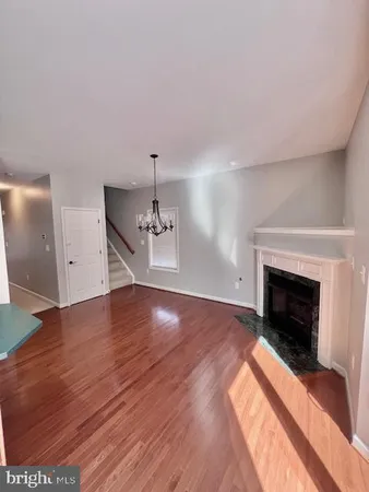 a view of empty room with wooden floor and fireplace