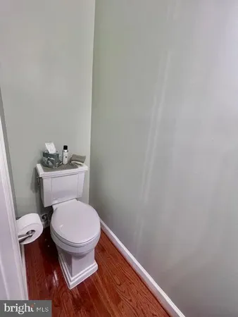 a white toilet sitting next to a white wall