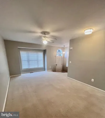 a view of an empty room with a ceiling fan