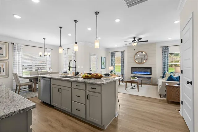 a kitchen with stainless steel appliances granite countertop stove top oven and cabinets
