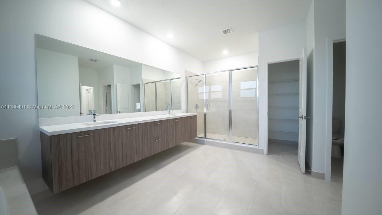 Sunset Lakes Miramar, FL 33029 - Photo 12 of 15 a bathroom with a double vanity sink mirror and shower