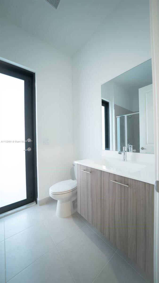 Sunset Lakes Miramar, FL 33029 - Photo 14 of 15 a bathroom with a toilet a sink and mirror