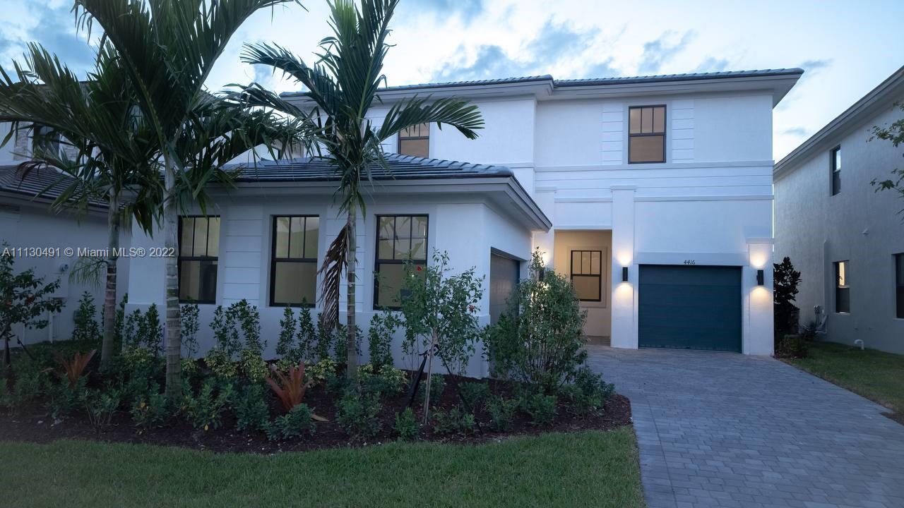 Sunset Lakes Miramar, FL 33029 - Photo 2 of 15 a front view of a house with a garden