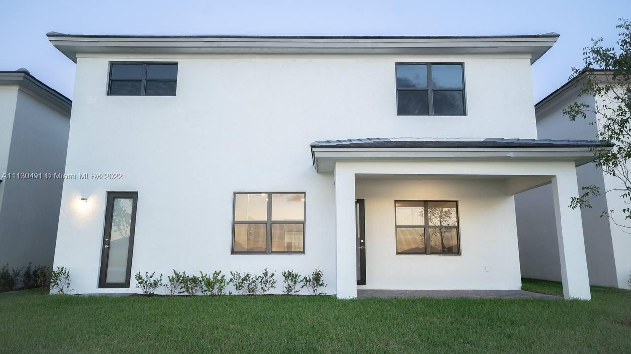 Sunset Lakes Miramar, FL 33029 - Photo 7 of 15 a front view of a house with a garden
