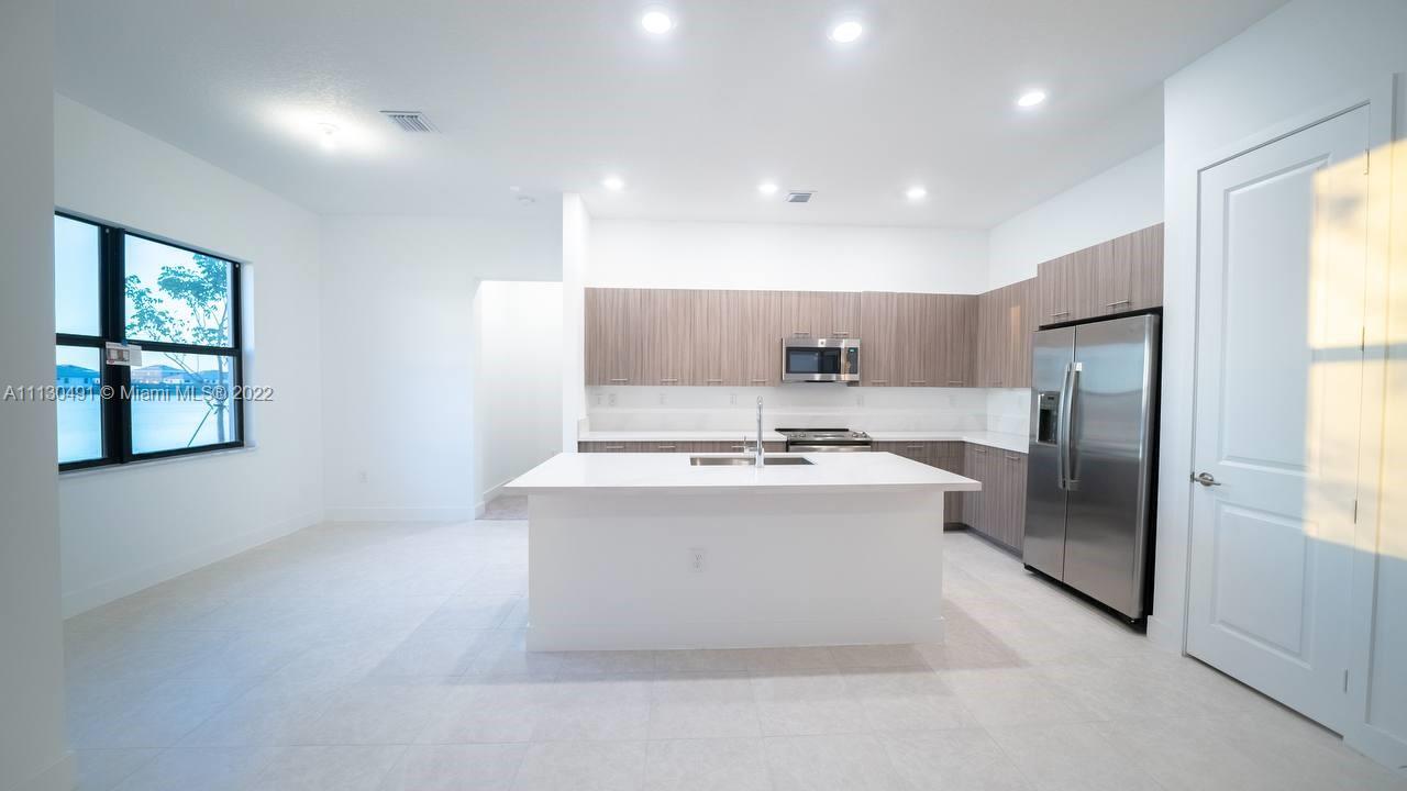 Sunset Lakes Miramar, FL 33029 - Photo 9 of 15 a view of kitchen with stainless steel appliances granite countertop refrigerator sink and window