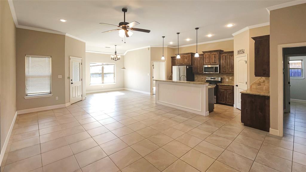 5765 Abbey Road Abilene, TX 79606 - Photo 2 of 11 a kitchen with stainless steel appliances kitchen island granite countertop a refrigerator and a sink