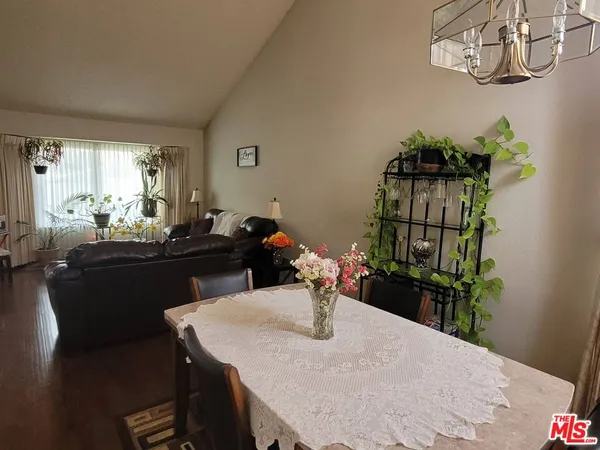 a dining room with furniture a chandelier and wooden floor
