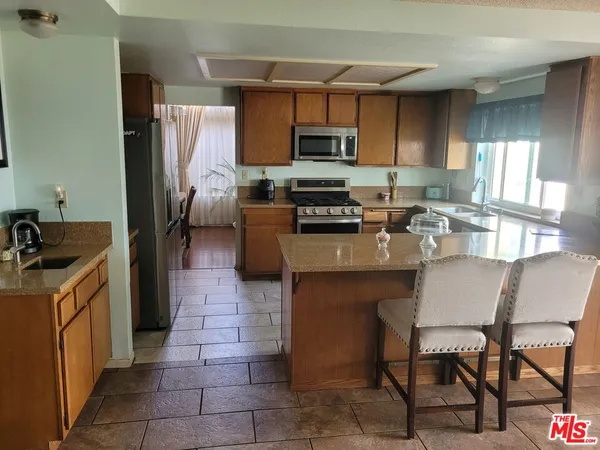 a kitchen with stainless steel appliances granite countertop a refrigerator stove microwave and sink