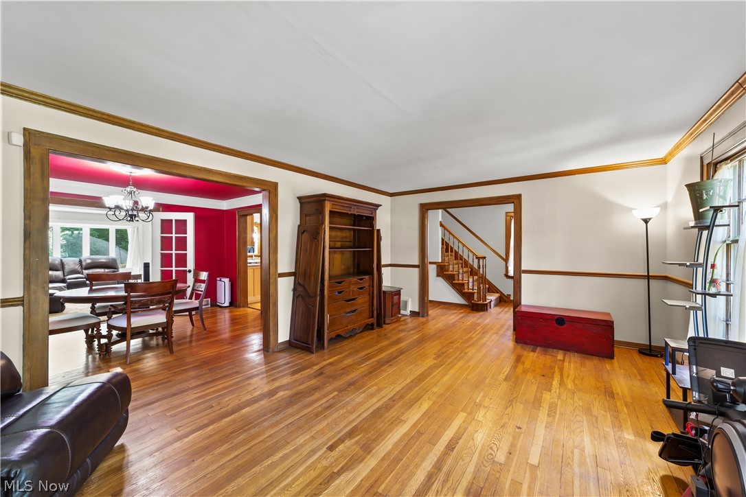 Living room featuring ornamental molding, hardwood / wood-style floors, and a chandelier