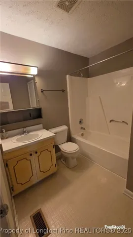 a bathroom with a granite countertop sink a toilet and a shower