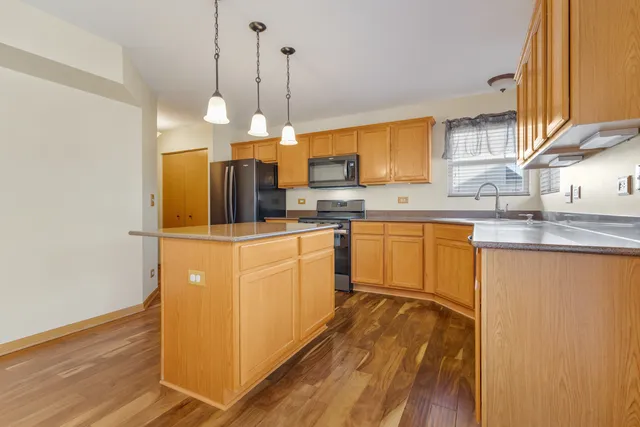 a kitchen with stainless steel appliances granite countertop a sink a stove and a refrigerator