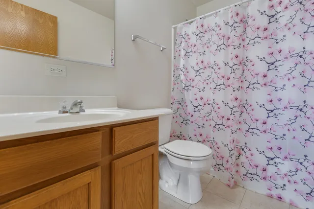 a bathroom with a granite countertop toilet and a sink