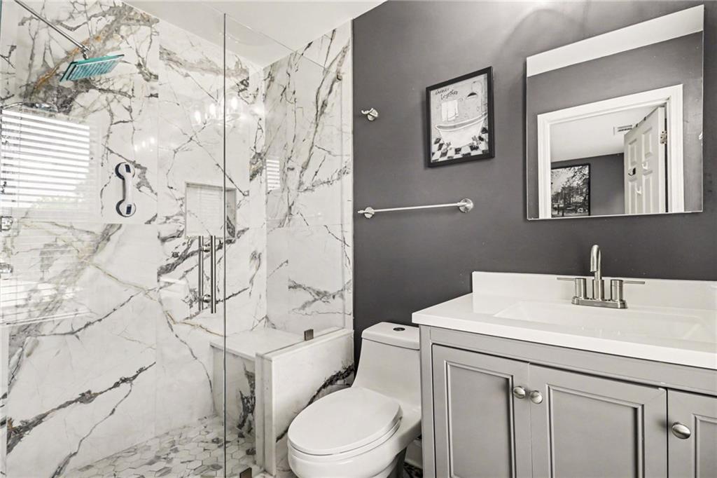 1180 Ridenour Boulevard, Unit 5 Kennesaw, GA 30152 - Photo 15 of 22 a bathroom with a toilet sink vanity and mirror