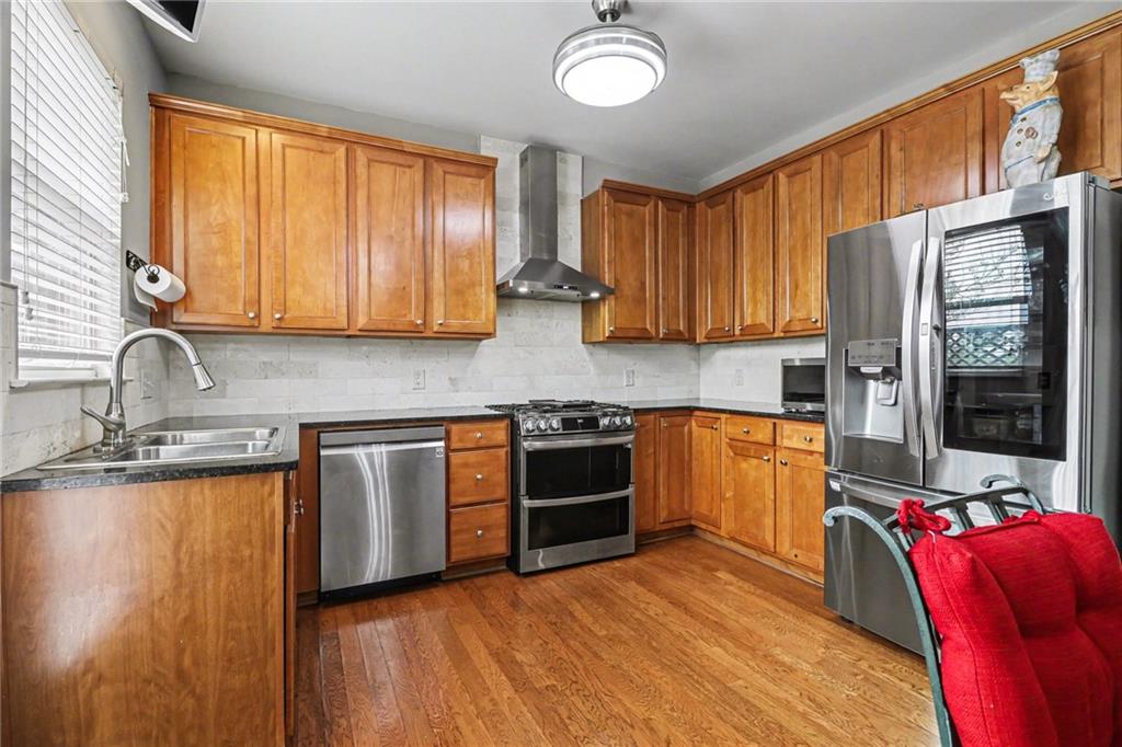 1180 Ridenour Boulevard, Unit 5 Kennesaw, GA 30152 - Photo 6 of 22 a kitchen with stainless steel appliances granite countertop a stove a sink and a microwave